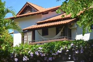 Casa con balcón y flores púrpuras en Bahia do Sonho, en Bombinhas