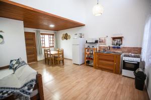 eine Küche mit Holzböden und eine Küche mit Kühlschrank in der Unterkunft Casa em Balneário Camboriú na Praia do Estaleiro in Balneário Camboriú