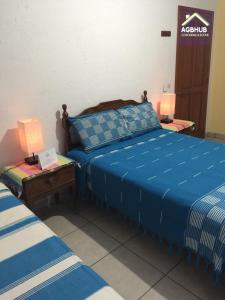 a bedroom with a blue bed and a table with lamps at AGBHub Coworking & Rooms in Oaxaca City