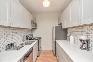 a kitchen with white cabinets and a stainless steel refrigerator at Calm Cozy Oasis in the Heart of Houston by Toyota Center in Houston