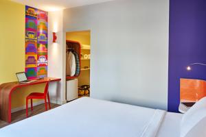 um quarto com uma cama e uma secretária com aaptop em Ibis Styles Balneário Camboriú - 1 Quadra do Mar no Balneário Camboriú