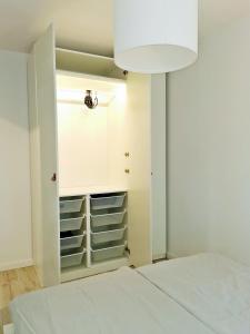 a bedroom with a bed and a closet with shelves at Nowoczesny apartament w sercu Wrocławia in Wrocław