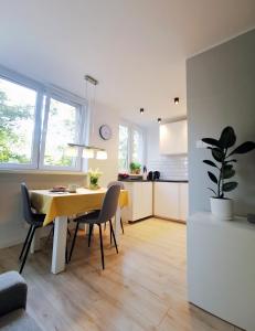 a kitchen and dining room with a table and chairs at Nowoczesny apartament w sercu Wrocławia in Wrocław