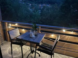 ein Tisch und Stühle auf einem Balkon in der Nacht in der Unterkunft Clos du chapitre T2 - 2pers in Brides-les-Bains