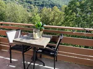 einem Holztisch und Stühlen neben einer Bank in der Unterkunft Clos du chapitre T2 - 2pers in Brides-les-Bains