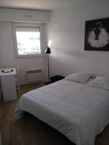 - une chambre avec un lit blanc et une fenêtre dans l'établissement Appartement 6 places à 200m de l'océan, à La Rochelle