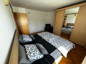 a bedroom with a black and white bed and a mirror at Apartment Sawetz - Ptuj in Ptuj