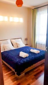 um quarto com uma cama com duas toalhas em Apartament z balkonem Przy parku em Varsóvia