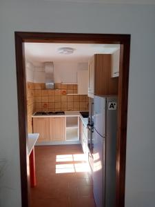 a kitchen with wooden cabinets and a refrigerator at MAISON BLANC in Aymavilles