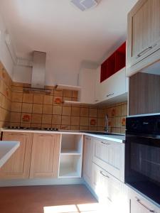una cocina con armarios blancos y electrodomésticos negros en MAISON BLANC, en Aymavilles