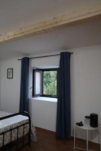 een slaapkamer met een bed en een raam bij Casa do Arco - Casa de Campo in Mezio