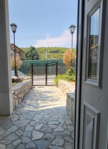 a door with a stone walkway leading to a gate at Apartment N.1 in Nov Dojran