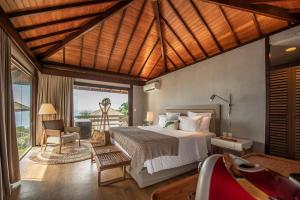 ein Schlafzimmer mit einem Bett, einem Stuhl und einem Fenster in der Unterkunft Pousada Morena in Fernando de Noronha