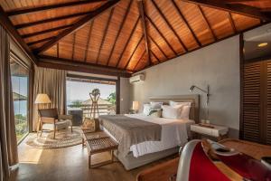 a bedroom with a bed and a chair and a window at Pousada Morena in Fernando de Noronha
