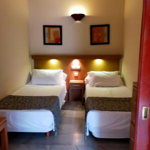 pokój hotelowy z dwoma łóżkami i stołem w obiekcie Atardecer Beach Costa w mieście Benalmádena