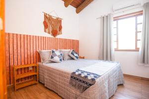 1 dormitorio con 1 cama con cabecero de madera en CURTA O VERÃO DE BC COM ESTILO! Casa no Estaleiro en Balneário Camboriú