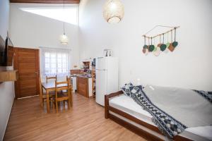 1 dormitorio con 1 cama y cocina con mesa en CURTA O VERÃO DE BC COM ESTILO! Casa no Estaleiro en Balneário Camboriú