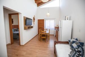 a kitchen and living room with a table and a refrigerator at CURTA O VERÃO DE BC COM ESTILO! Casa no Estaleiro in Balneário Camboriú