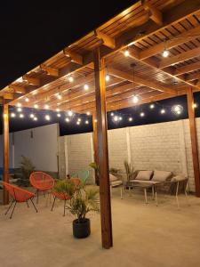 een patio met stoelen, tafels en verlichting bij La Estancia Hotel Ica in Ica