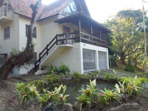 a house with a pond in front of it at Casa Penedo Martinelli - Tranquilidade e muito verde in Penedo