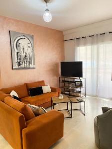 a living room with two couches and a flat screen tv at Marina Agadir appartement standing 90m2 + piscine in Agadir
