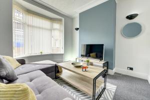 uma sala de estar com um sofá e uma mesa em A Gem in Central Hull - Sleeps 6 em Hull