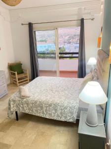 a bedroom with a bed and a large window at Marina Agadir appartement standing 90m2 + piscine in Agadir