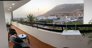 una persona sentada en un balcón con vistas a una montaña en Marina Agadir appartement standing 90m2 + piscine en Agadir