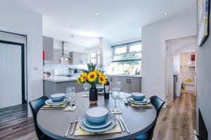 a dining room table with a vase of flowers on it at Pristine 3-bed home in Crewe by 53 Degrees Property, ideal for Business & Contractors, Great Parking - Sleeps 5 in Church Coppenhall