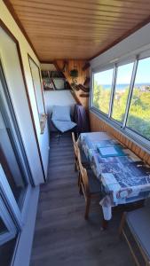 een eettafel in een tiny house met ramen bij Appartement en bord de mer in Villers-sur-Mer