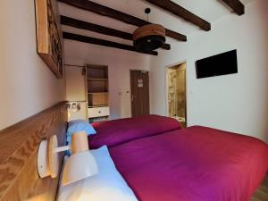 1 dormitorio con 2 camas con sábanas moradas en Gîte l'Interlude, en Mons