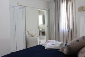 a bedroom with a bed with towels and a chair at Book and Bed in Maglie