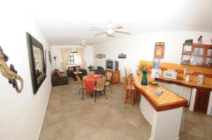 a kitchen and living room with a table and chairs at Hacienda San Jose Condo by BVR in Playa del Carmen