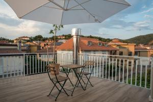 een balkon met een tafel en stoelen en een parasol bij Rosa's House in Vazzano