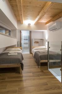 twee bedden in een kamer met houten vloeren bij Rosa's House in Vazzano