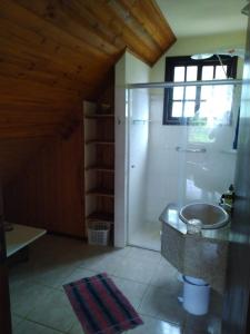 a bathroom with a sink and a shower in a room at Casa Penedo Martinelli - Tranquilidade e muito verde in Penedo