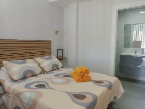 ein Teddybär auf einem Bett in einem Schlafzimmer in der Unterkunft Rentaly Holidays Apartamento Artes de Arcos Almería in Almería