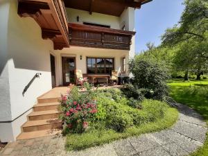 Casa con porche y patio con flores en Haus Polleichtner, en Marquartstein