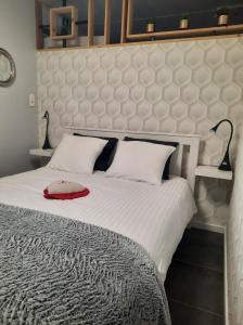 a bedroom with a large white bed with two lamps at Gîte le Quesnoy in Martimont