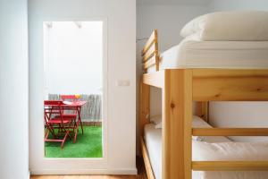 1 dormitorio con 1 cama y 1 mesa con silla roja en Minimal Rooms by ELE Apartments, en Málaga