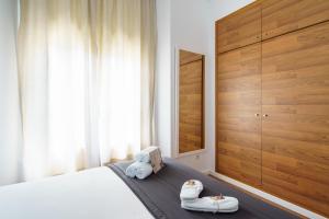 Un dormitorio con una cama con dos pares de zapatos. en Minimal Rooms by ELE Apartments, en Málaga