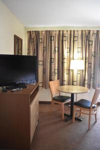 a hotel room with a table and chairs and a television at South Hills Motel in Pittsburgh