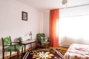 a bedroom with a bed and a table and two chairs at Generous family home in Vişeu de Sus