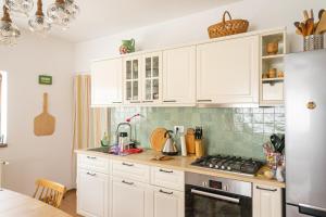 a kitchen with white cabinets and a stove top oven at Generous family home in Vişeu de Sus