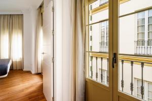 um quarto com uma porta e uma janela em Minimal Rooms by ELE Apartments em Málaga