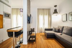 sala de estar con sofá y mesa en Minimal Rooms by ELE Apartments, en Málaga