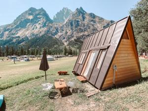 a tiny house in a field with mountains in the background at Hobo Camping in Courmayeur