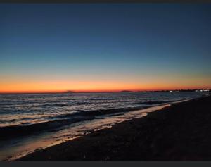 vista para a praia ao pôr-do-sol com o oceano em MUREX em Marsala