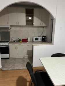 a kitchen with white cabinets and a table and chairs at Casa Maria in Cluj-Napoca