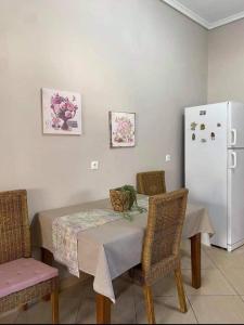 uma mesa de jantar com cadeiras e um frigorífico branco em Sady's House em Yimnón